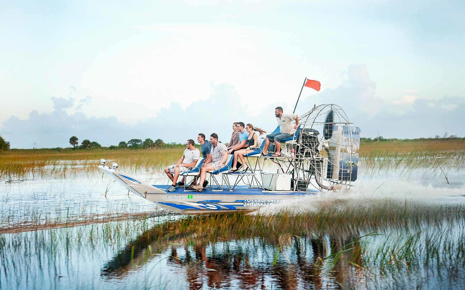 Airboat gliding through Everglades at Sawgrass Recreation Park with passengers.