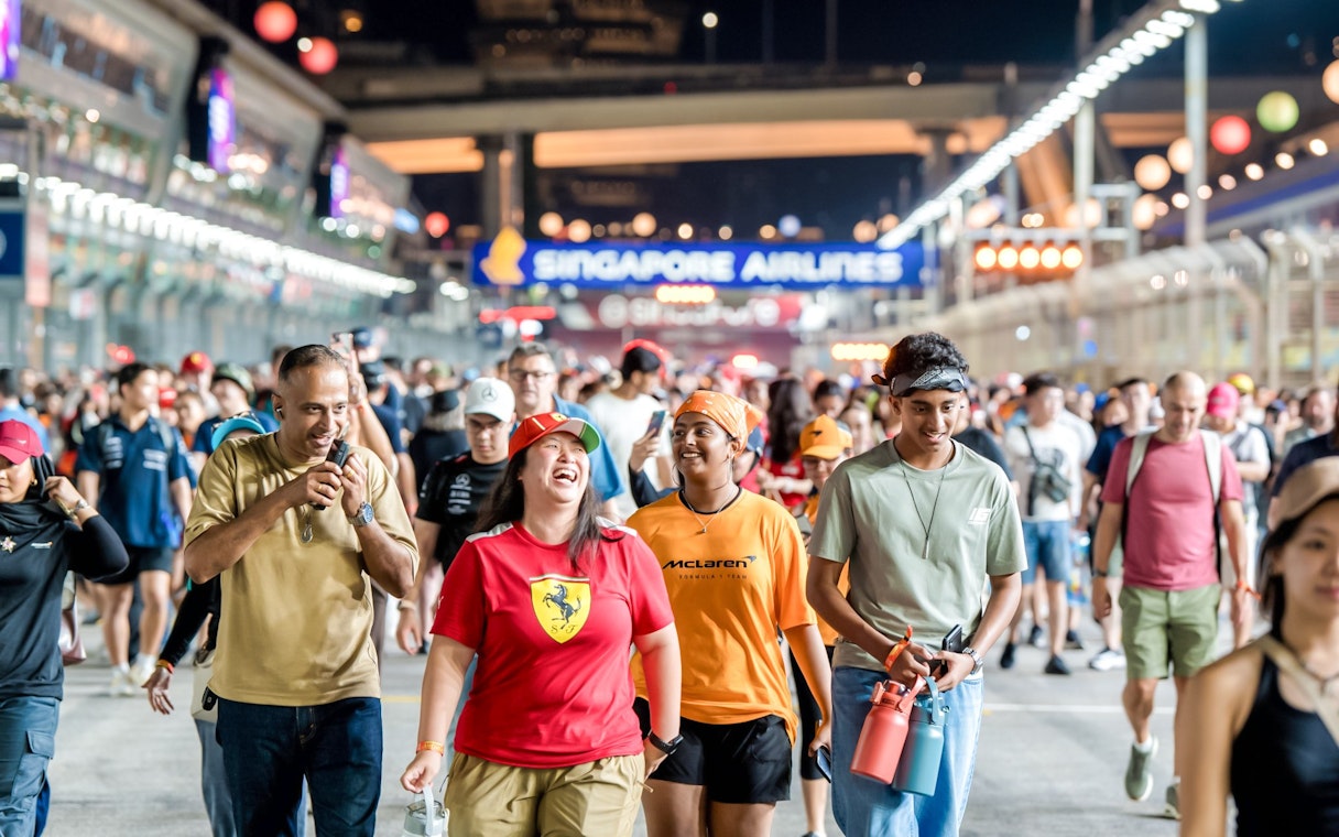 Crowd walking the Singapore Grand Prix track at night after the race.