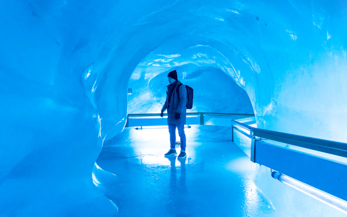Person exploring glacier cave in Titlis, Switzerland.