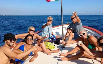 Group enjoying limoncello on a Capri boat tour with a swimming stop.