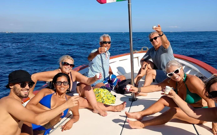 Group enjoying limoncello on a Capri boat tour with a swimming stop.