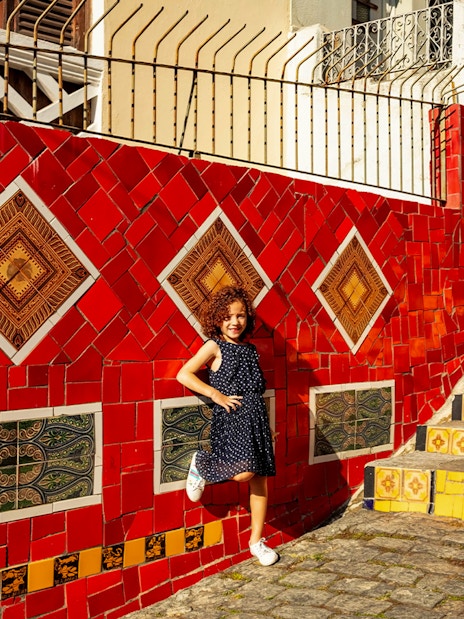 Child posing on colorful Selarón Steps in Rio de Janeiro.
