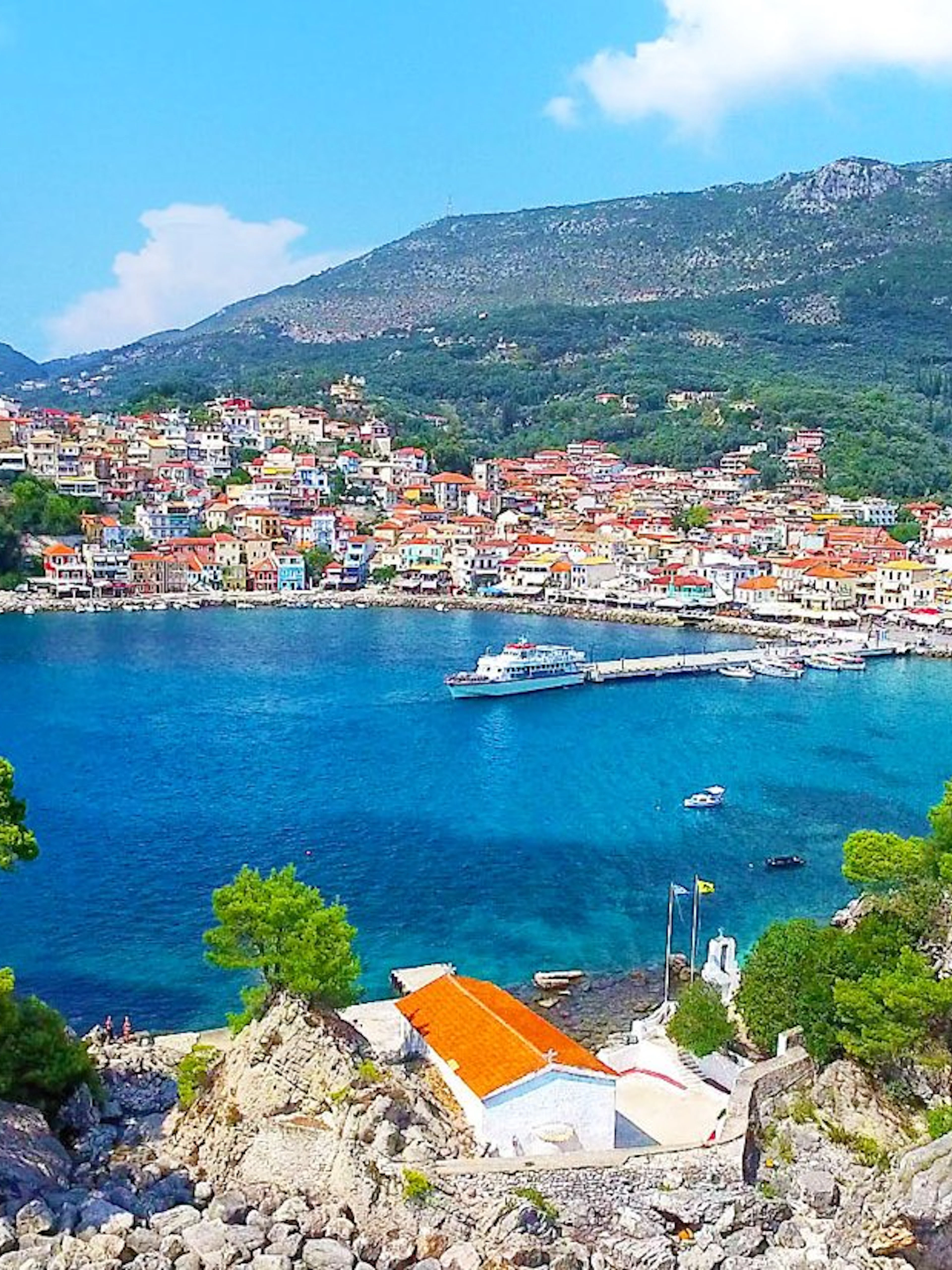 Parga city coastline with colorful buildings and boats in Corfu, Greece.