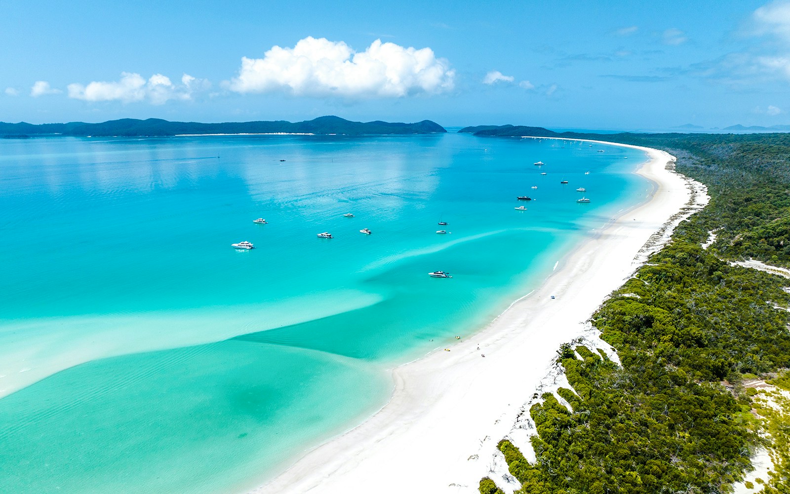Aerial view of Whitehaven Beach, Whitsundays, with turquoise waters and anchored boats.