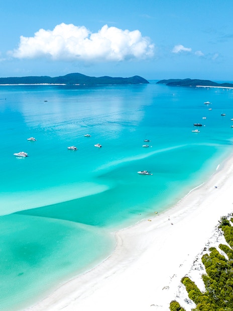 Aerial view of Whitehaven Beach, Whitsundays, with turquoise waters and anchored boats.