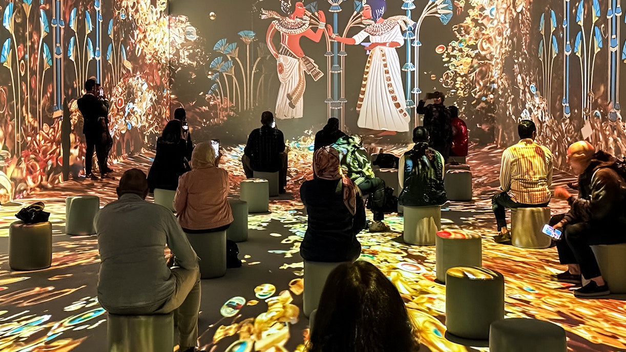 Visitors observing interactive digital exhibition at Grand Egyptian Museum, Cairo.