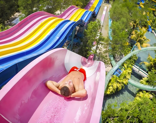 Visitors enjoying thrilling rides at ESCAPE Theme Park Penang, a popular tourist attraction in Malaysia