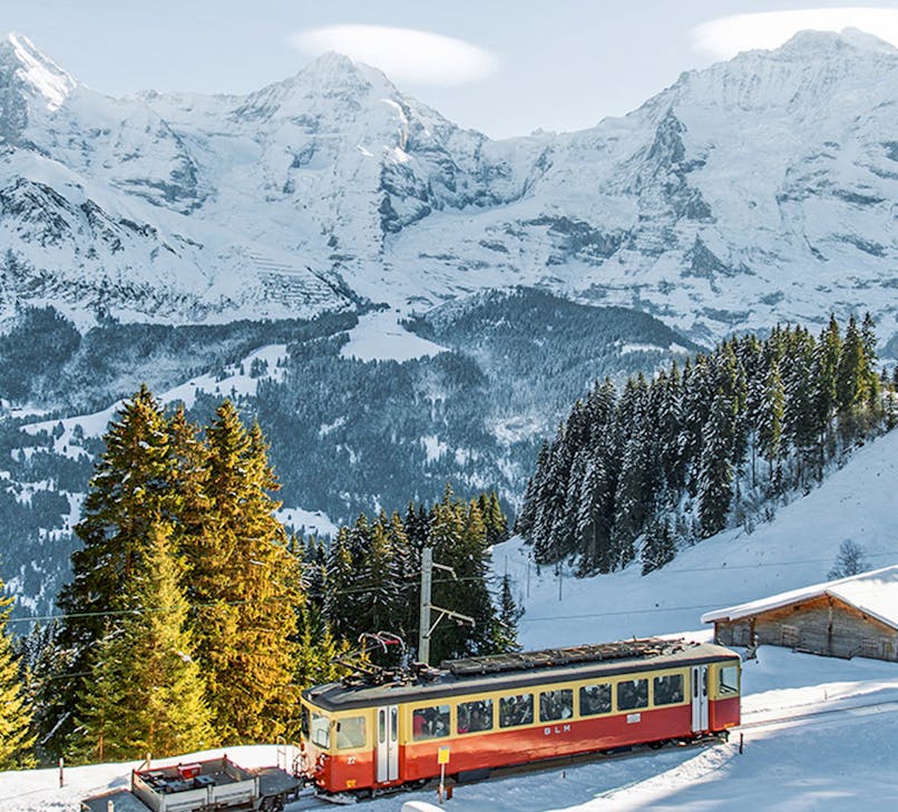Train journey through snow-covered Swiss Alps from Interlaken to Jungfraujoch.