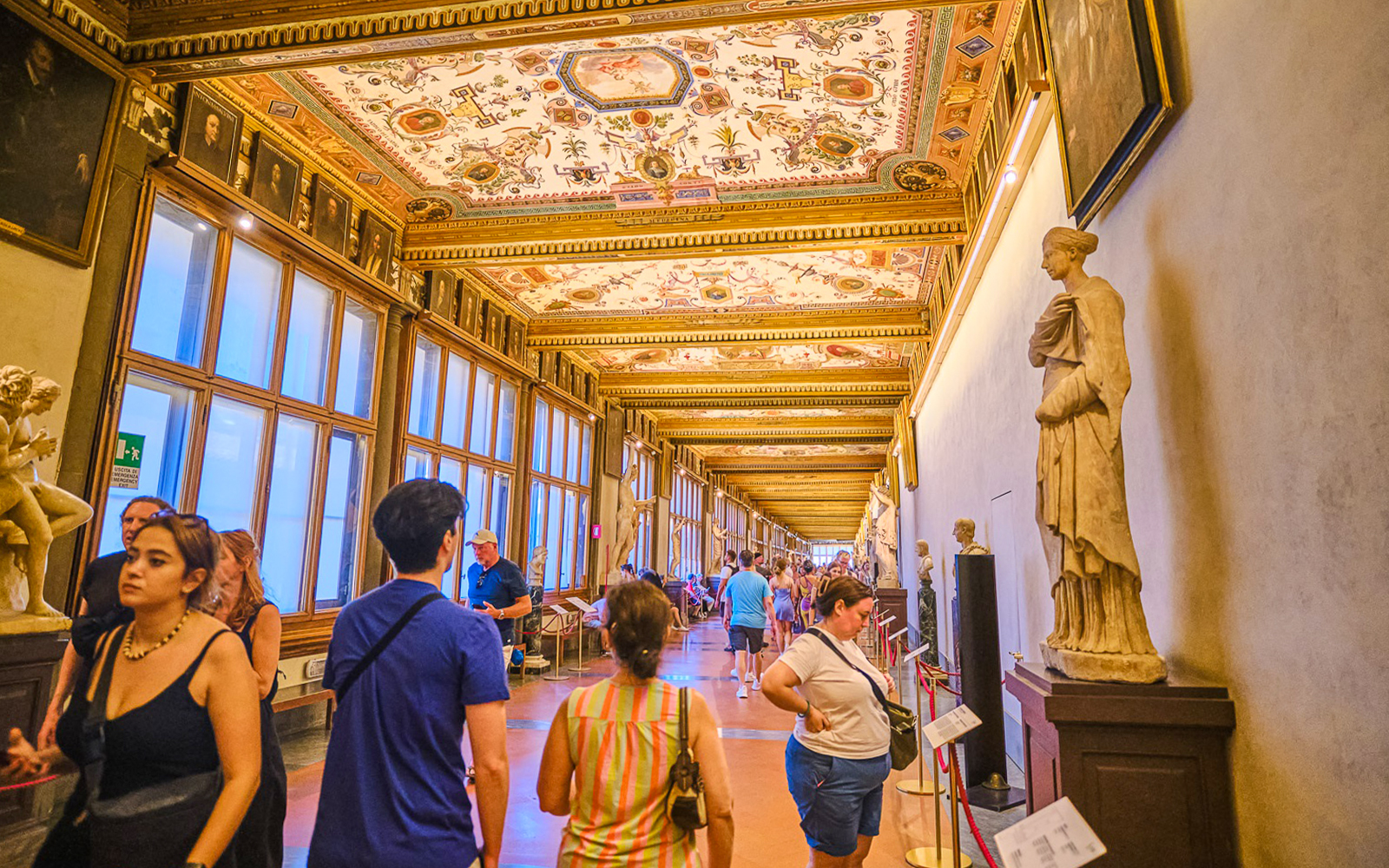 Visitors exploring the ornate Vasari Corridor in the Uffizi Gallery, Florence.