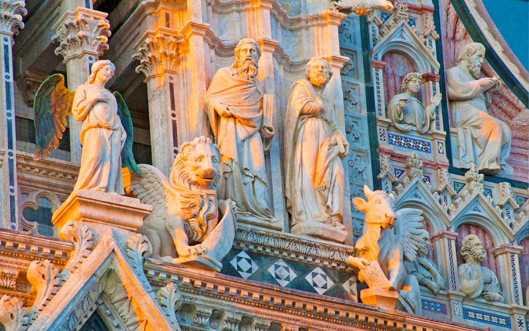 Sculptures on the facade of Siena Cathedral during a small-group guided tour.