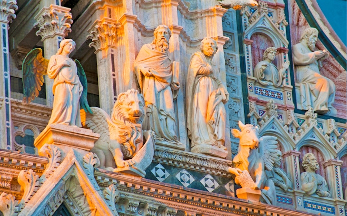Sculptures on the facade of Siena Cathedral during a small-group guided tour.