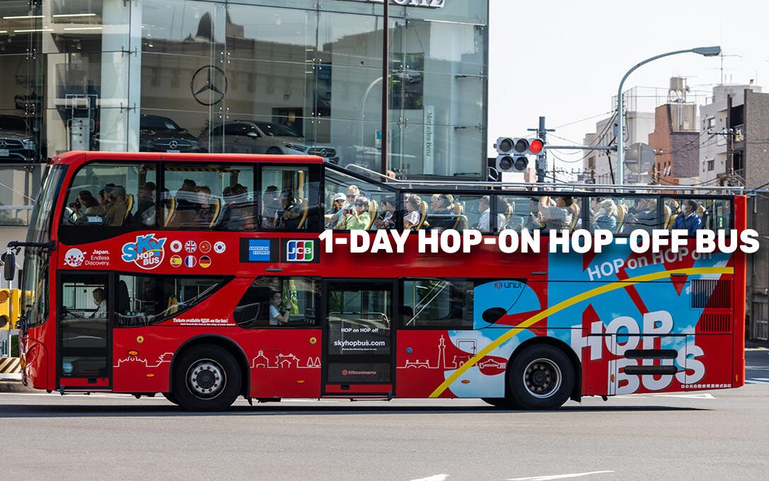 Red double-decker bus for Tokyo MegaPass tour with passengers on top deck.