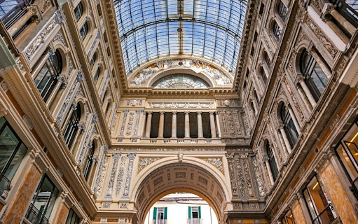 Interior of Galleria Umberto I in Naples with ornate architecture and glass ceiling.