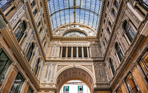 Interior of Galleria Umberto I in Naples with ornate architecture and glass ceiling.