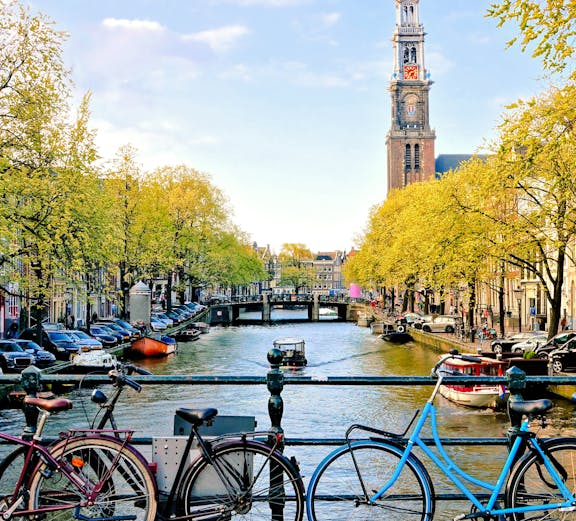 Bicycles parked on a bridge over a canal near Amsterdam Centraal Station.
