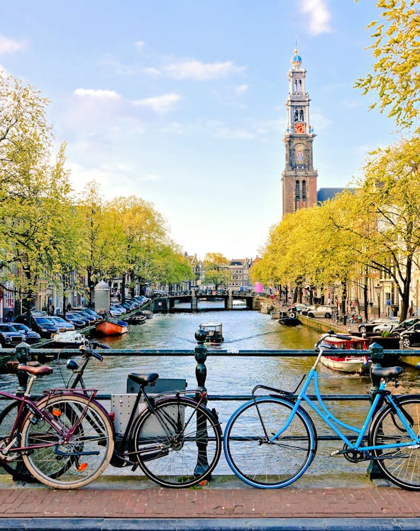 Bicycles parked on a bridge over a canal near Amsterdam Centraal Station.