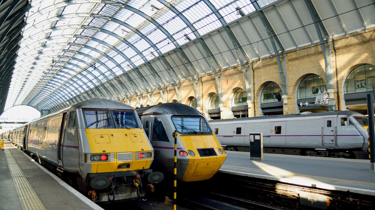 Trains at King's Cross Station in London under arched glass roof.