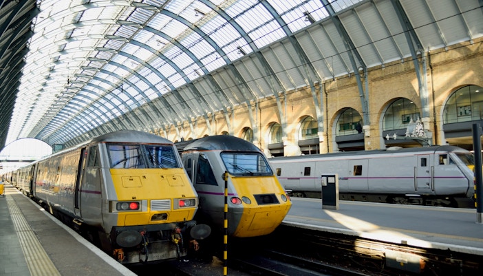 Trains at King's Cross Station in London under arched glass roof.