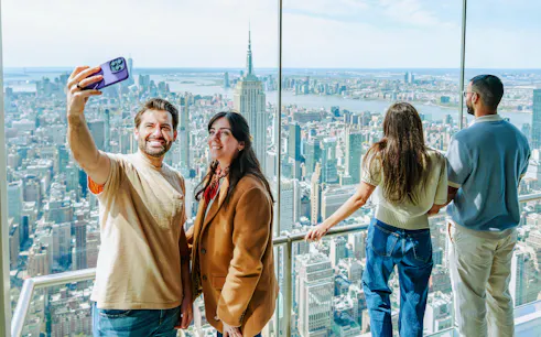 Visitors taking a selfie with New York City skyline from SUMMIT Ascent Experience.