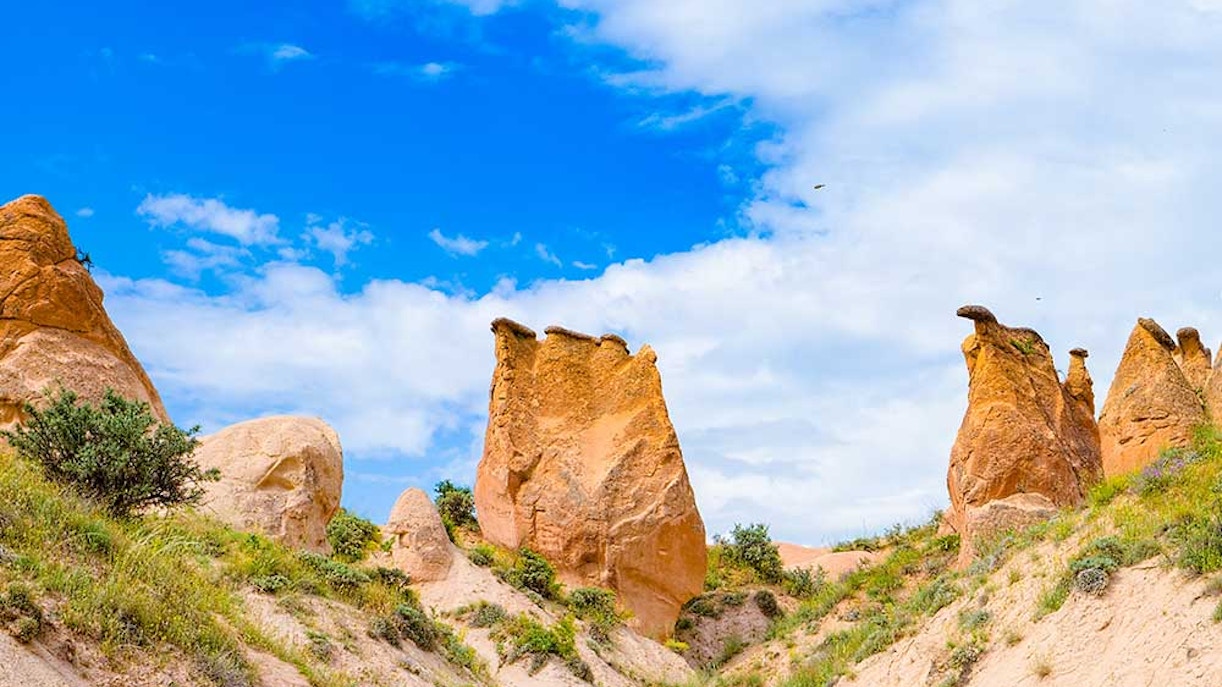 Rock formations in Devrent Imagination Valley, Cappadocia, under a blue sky.