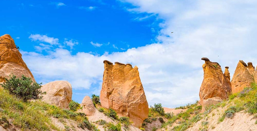 Rock formations in Devrent Imagination Valley, Cappadocia, under a blue sky.