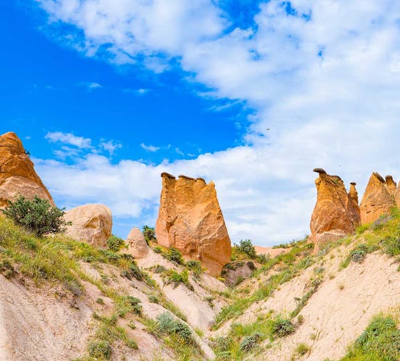 Rock formations in Devrent Imagination Valley, Cappadocia, under a blue sky.