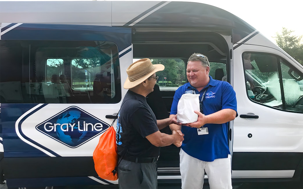 Guide greeting passenger for Kennedy Space Center round-trip transfer.