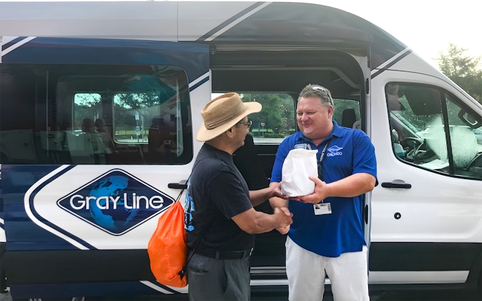 Guide greeting passenger for Kennedy Space Center round-trip transfer.
