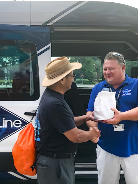 Guide greeting passenger for Kennedy Space Center round-trip transfer.