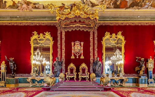 Throne room with ornate gold decor inside Royal Palace of Madrid.