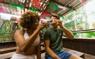Visitors enjoying a toast at Cancun Extreme Adventuring Park under festive decorations.