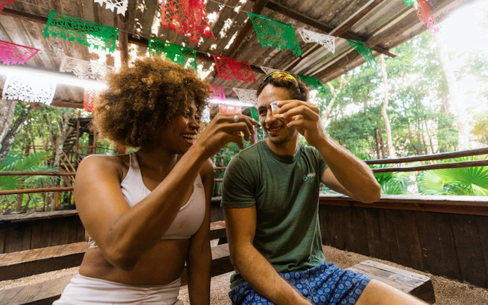 Visitors enjoying a toast at Cancun Extreme Adventuring Park under festive decorations.