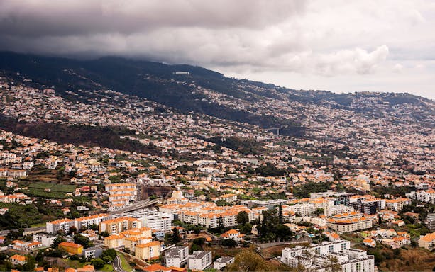 Aerial view of Funchal and Câmara de Lobos with hillside houses and lush landscape.