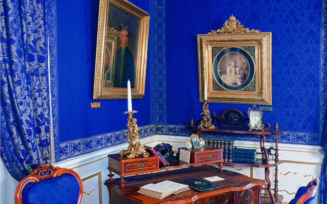 Inside view of Godollo Royal Palace with ornate blue decor and antique furniture.