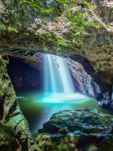 Waterfall cascading into a cave pool at Springbrook National Park.