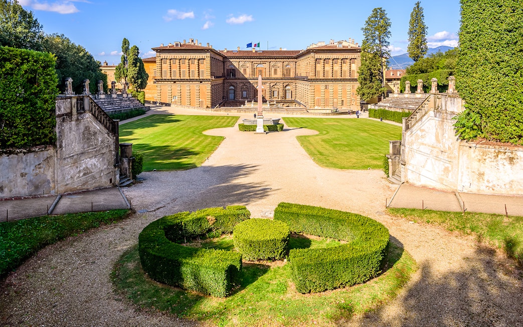 Boboli Gardens with Pitti Palace in Florence, featuring manicured hedges and a central obelisk.