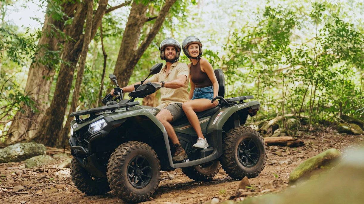 Couple riding quad bike through forest on Bel Ombre tour.