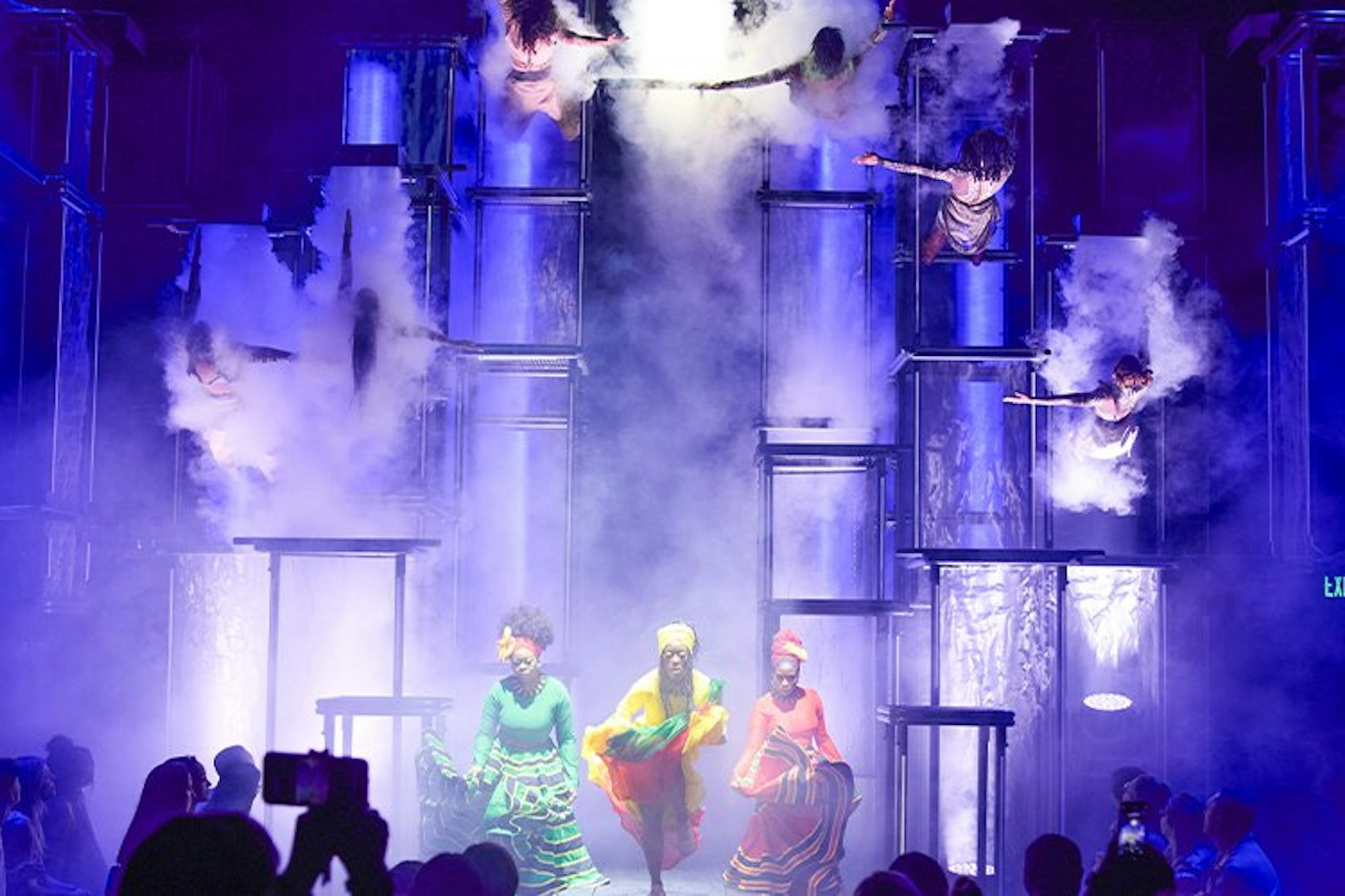 Performers on stage at Bob Marley The Show, Vegas, with acrobats and vibrant lighting.