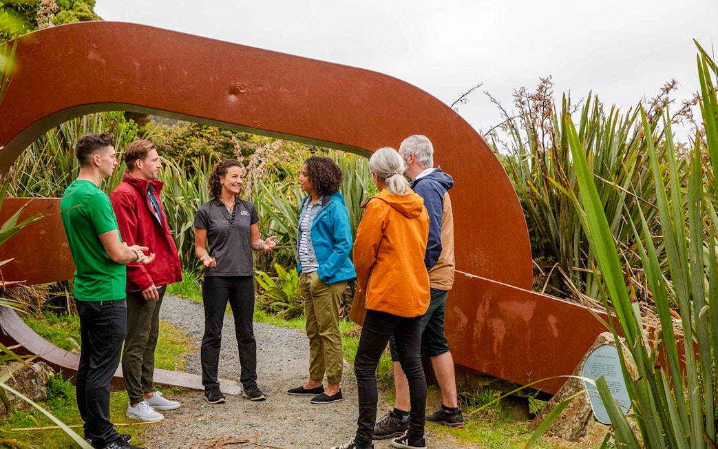 Tour group with guide at Stewart Island sculpture garden.