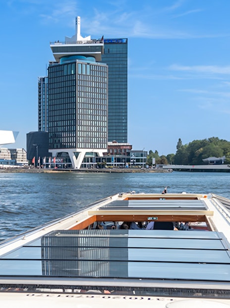 Canal boat cruising past A'DAM Tower and Eye Film Museum in Amsterdam.