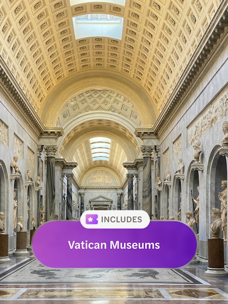 Vatican Museum hall with classical sculptures and ornate ceiling, Rome.