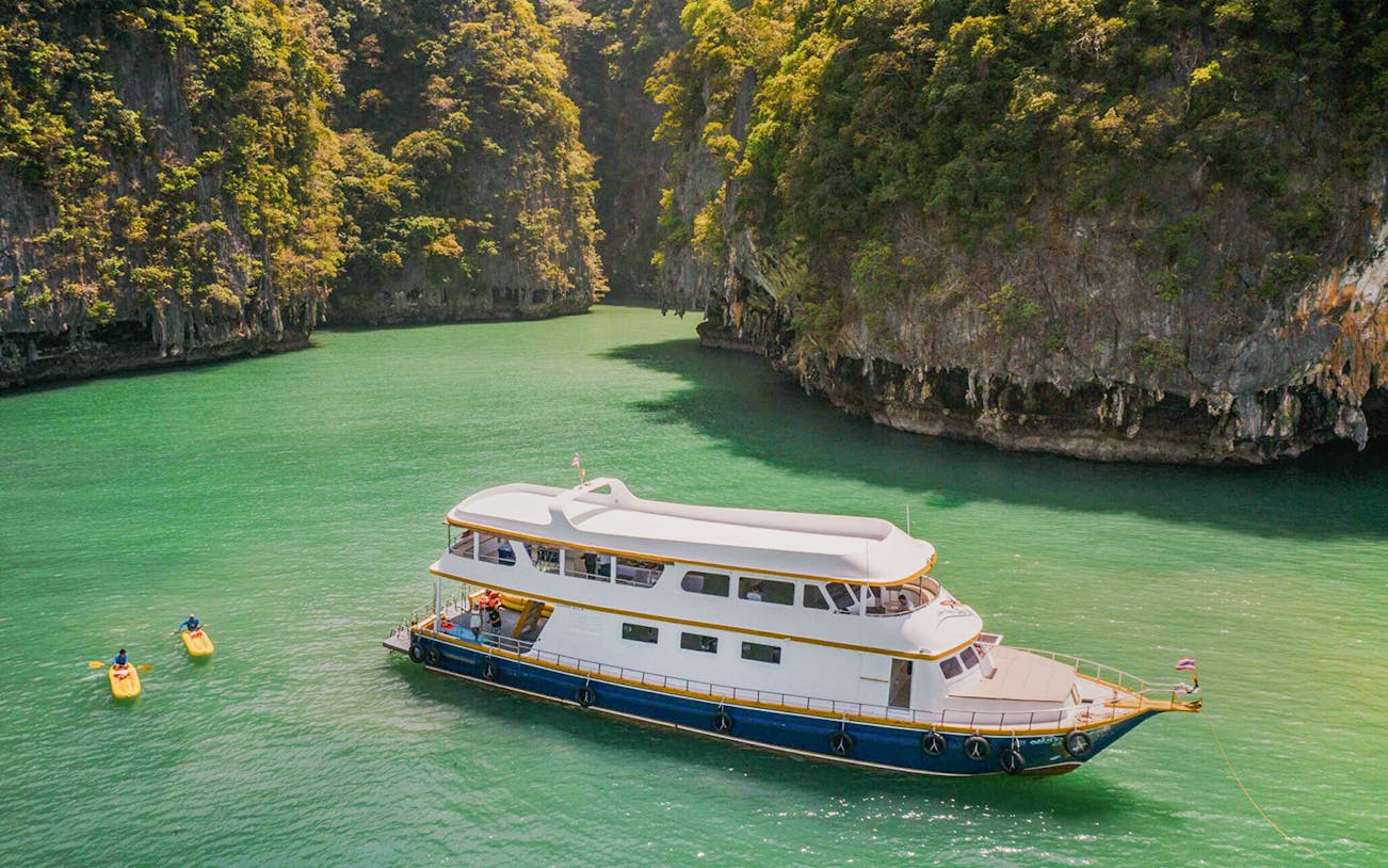Boat tour through limestone cliffs at Ao Phang Nga National Park, Thailand.