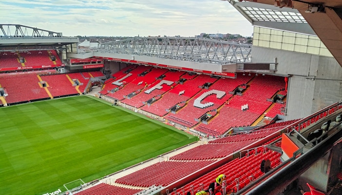 Liverpool FC stadium with red seats and field, view from the stands.