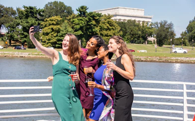 Guests taking selfies on the deck during a brunch cruise in Washington DC.