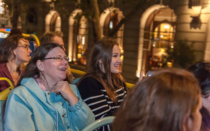Passengers enjoying Tootbus London evening tour on an open-top bus.