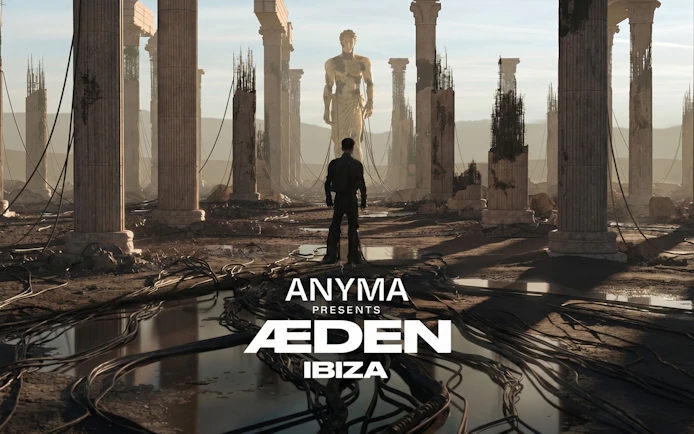 Man stands among ancient ruins with towering statue, Anyma presents AEDEN UNVRS, Ibiza.