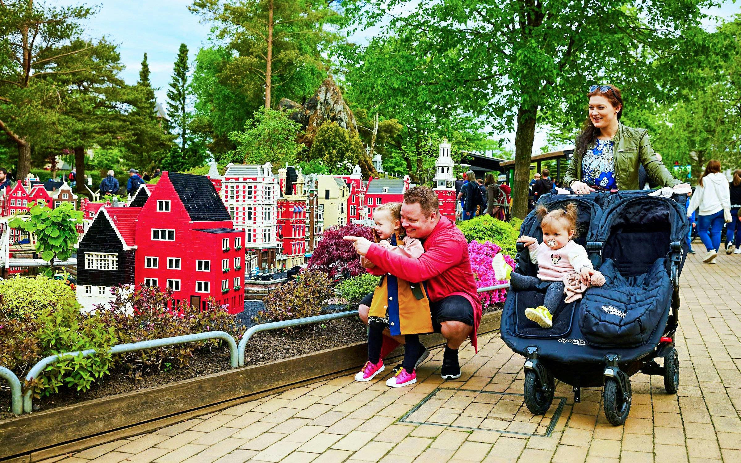 Family exploring LEGO miniature buildings at LEGOLAND® Billund.