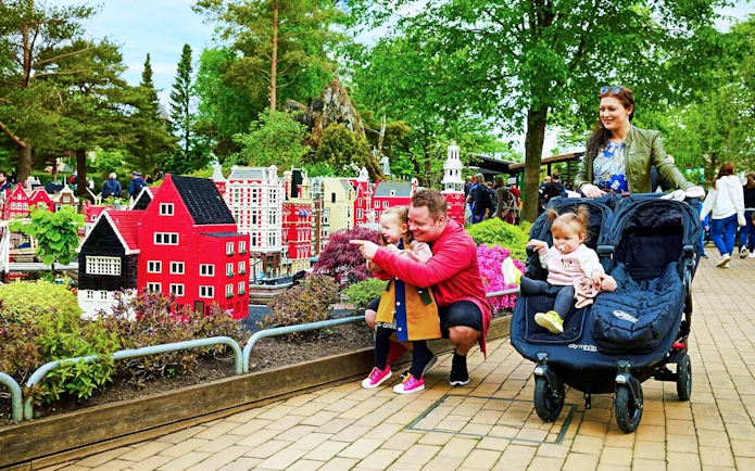 Family exploring LEGO miniature buildings at LEGOLAND® Billund.