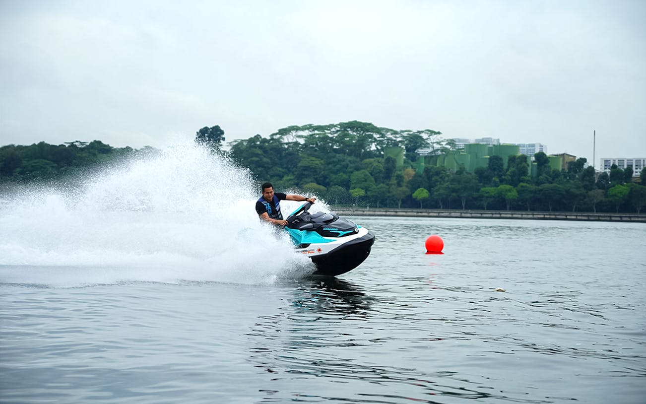 Seadoo rider navigating waters in Johor Bahru with lush greenery in the background.