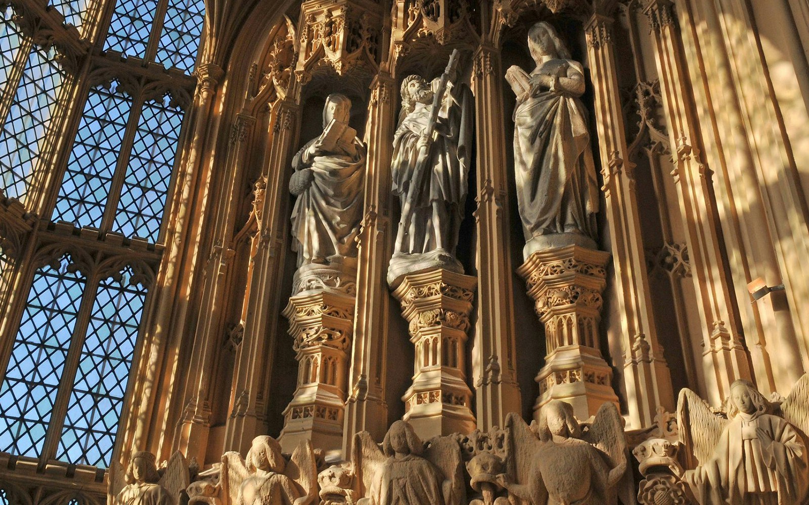 Statues inside Westminster Abbey, London, highlighting intricate Gothic architecture.